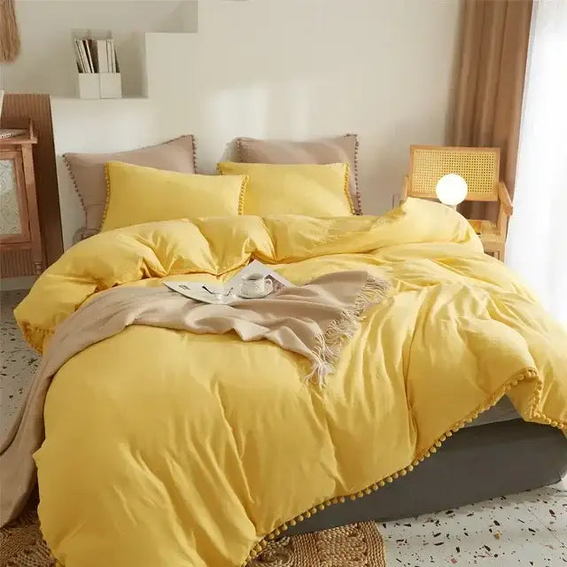 Bright yellow quilted duvet cover set with pom-pom trim complementing the mint green bedroom cover set design