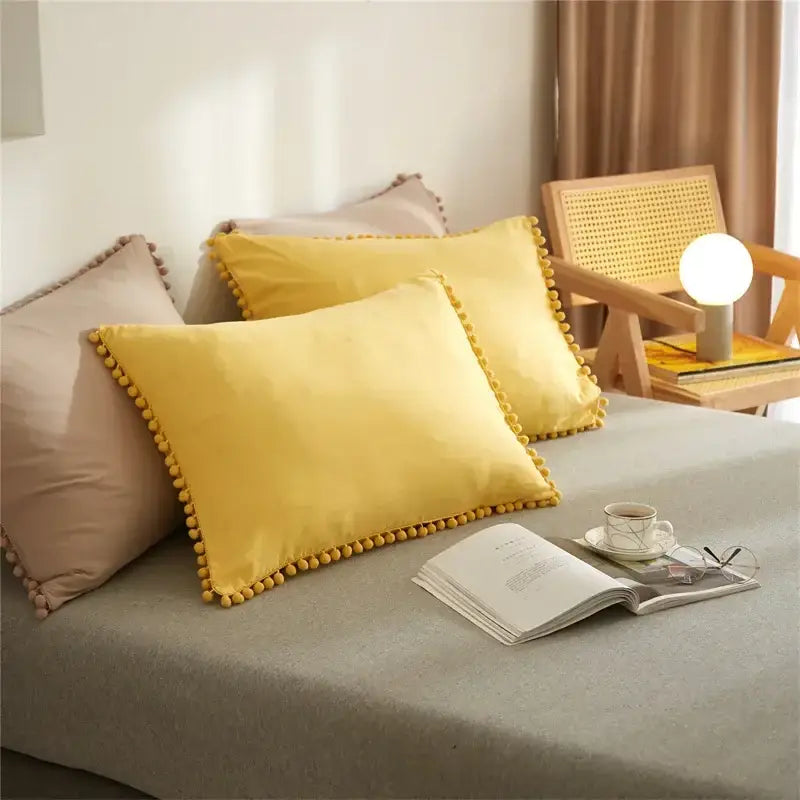Bright yellow velvet pillow with decorative pom-pom border in mint green quilted duvet cover set with pom pom trim