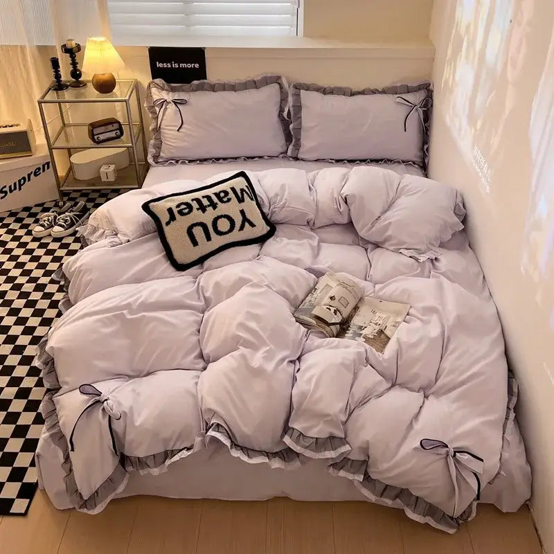 Mint green ruffled cotton embroidery bedding set featuring a soft lavender quilt with decorative black bows and layered design