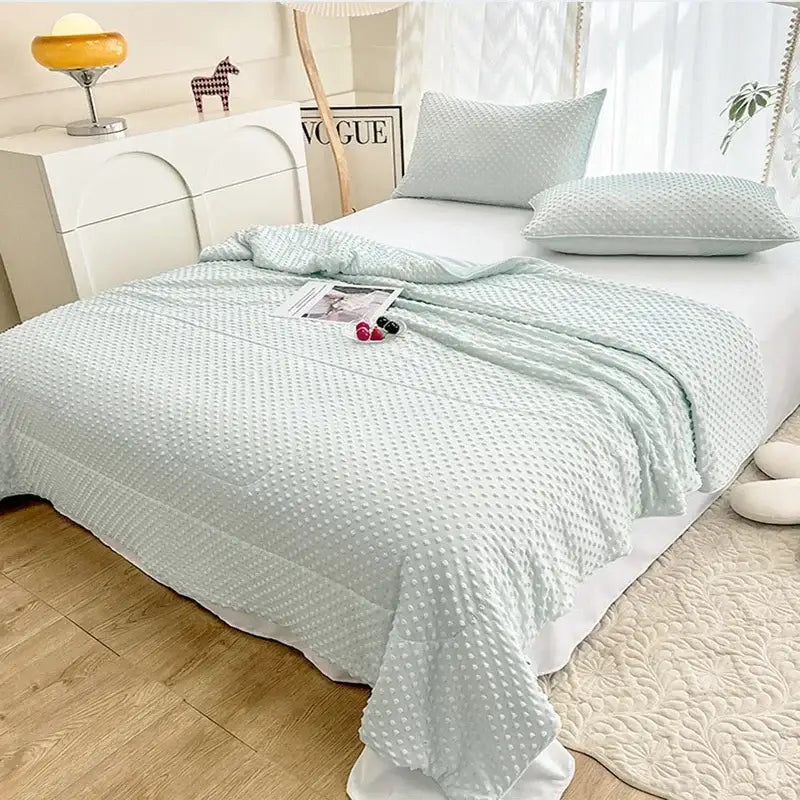 Light mint green quilted cooling massage blanket with textured raised dot pattern for bedroom comfort by decorbites cooling massage