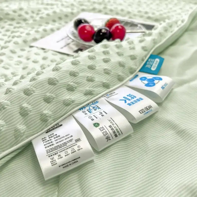Mint green decorbites cooling massage blanket with subtle dotted texture and white care labels for bedroom comfort