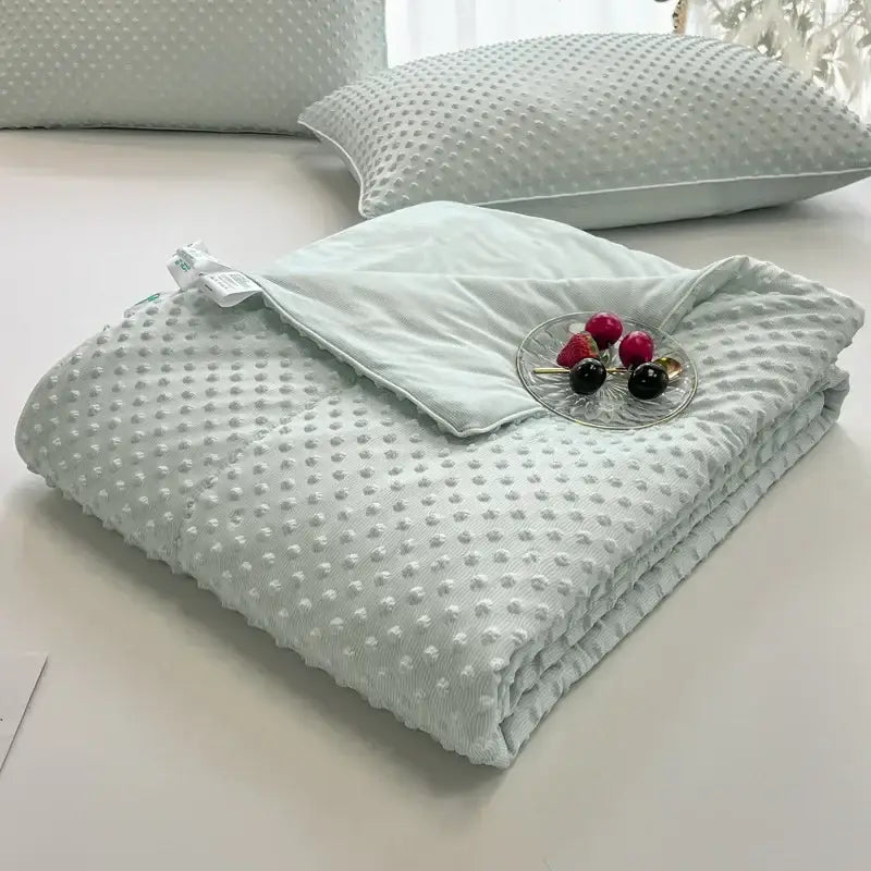 A soft light mint green quilted decorbites cooling massage blanket with raised dot texture for bedroom comfort