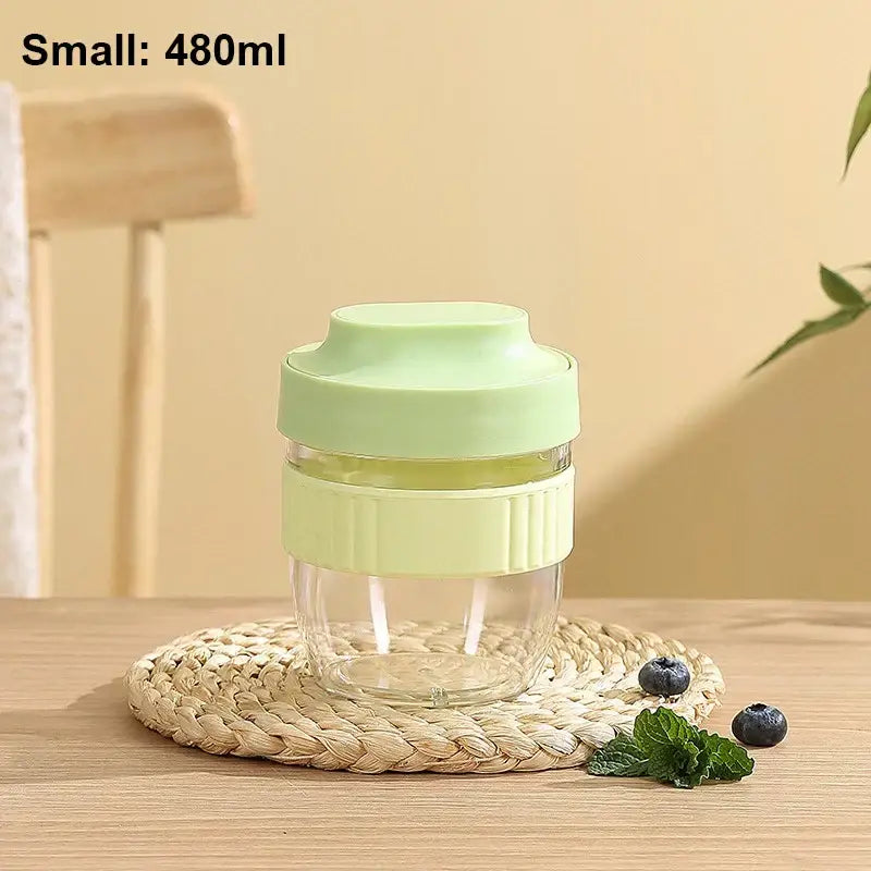 A clear glass decorbites breakfast cup with a light green silicone lid and grip band 480ml small capacity