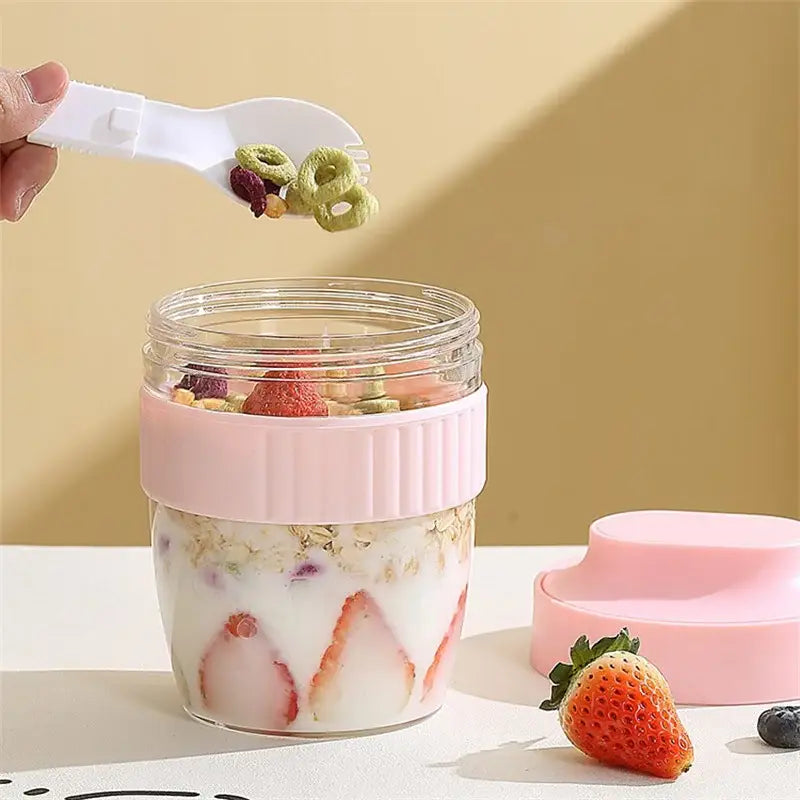 Mint green and yellow decorbites breakfast cup glass container with pink silicone lid filled with yogurt granola and strawberries