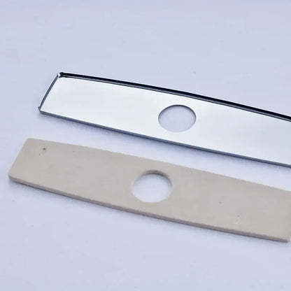 Two rectangular metal and beige plastic deck plate escutcheon inserts with central hole for kitchen and bathroom sinks