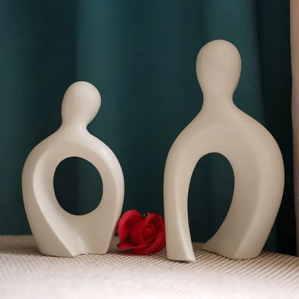 Two minimalist off-white ceramic couple love sculpture with smooth abstract forms and circular cutouts for decorbites decorbites couple