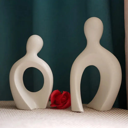 Two minimalist off-white ceramic couple love sculpture with smooth abstract forms and circular cutouts for decorbites decorbites couple