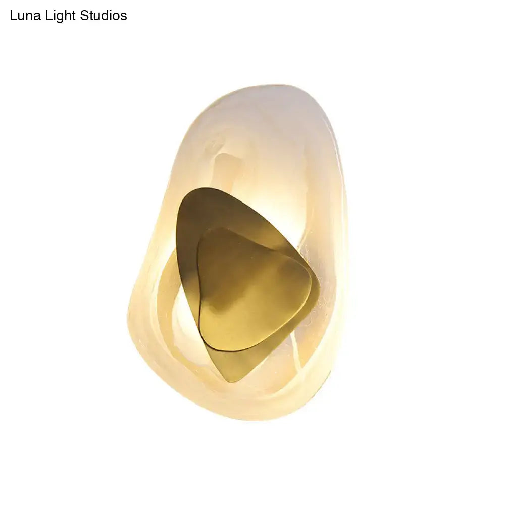 Modern abstract clear glass rock wall sconce with direct wired electric connection, translucent acrylic and brass accents in black and gold