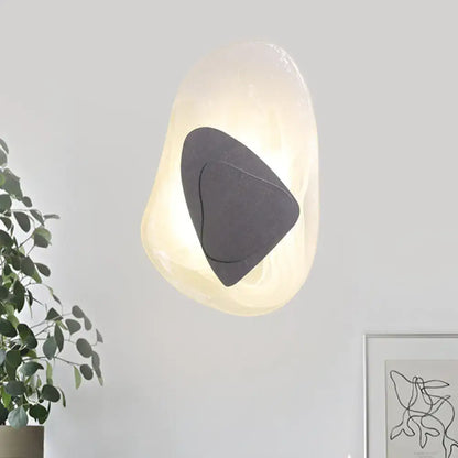 Modern abstract clear glass rock wall sconce with warm glow direct wired electric design in black and gold for dining room