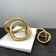 Modern abstract gold ring knot sculpture with smooth intertwined loops for living room art decor