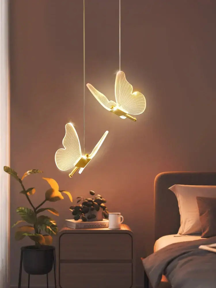 Two elegant modern acrylic butterfly led chandelier pendant lights with translucent wings and gold bodies for bedroom decorbites butterfly led lighting
