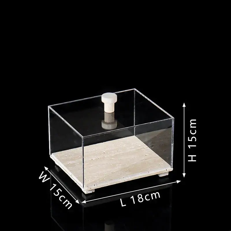 Modern acrylic display case with clear square box, light beige travertine base, and white cylindrical knob for dining room