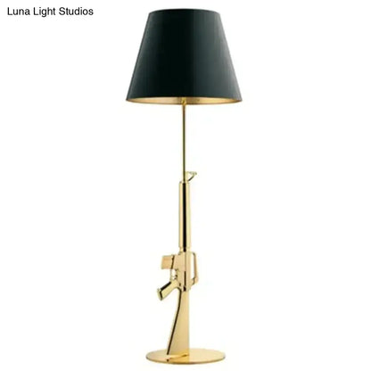 Modern ak47 gun lounge floor lamp in silvery gold lustre with black conical shade and gold interior lining for bedroom lighting