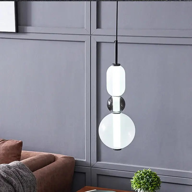 Modern pendant lights with three stacked colorful glass balls in amber cream and black for dining room decor