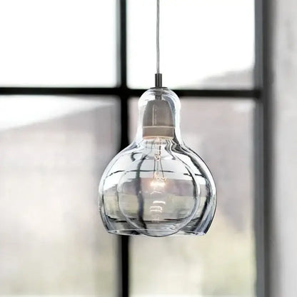 Modern amber and gray glass pendant lights featuring a clear bulbous glass pendant with vintage filament for dining room use