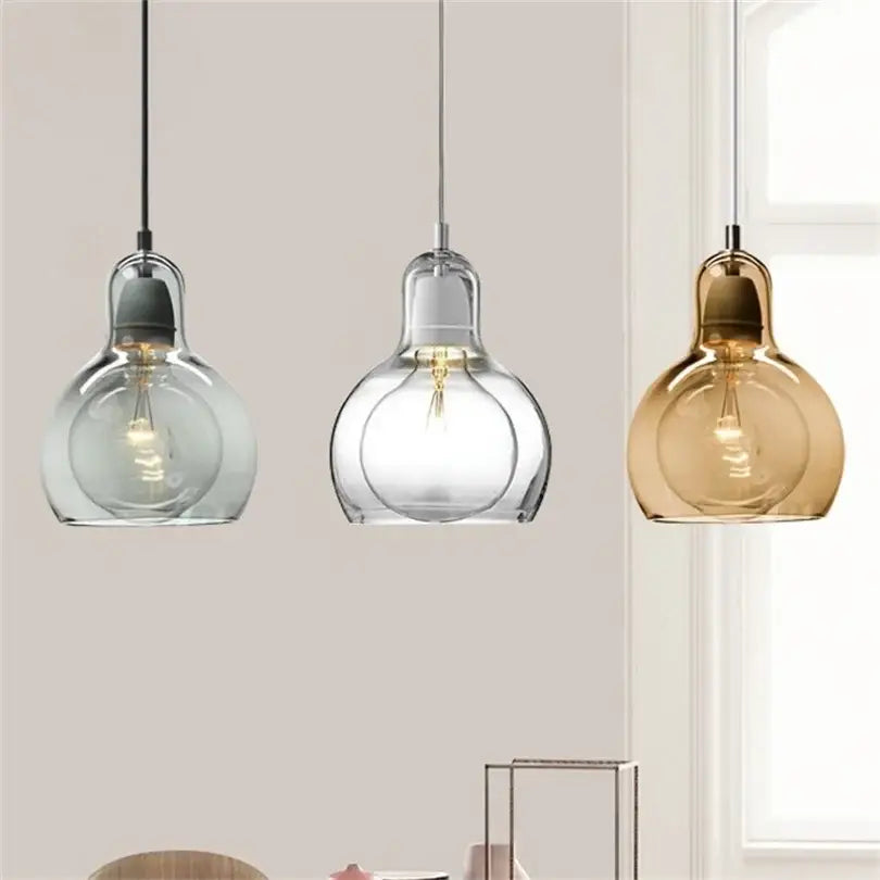 Three modern glass pendant lights with amber, gray, clear, and frosted globes for dining room lighting