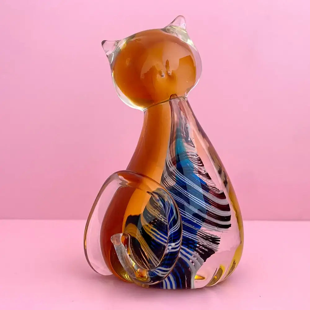 Modern amber and black glass cat figurine with swirling blue white and black patterns for living room decor