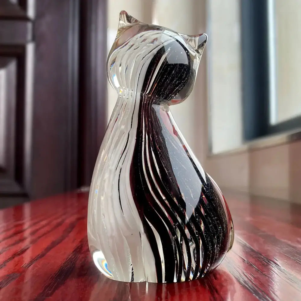 Modern amber and black glass cat figurine featuring flowing black and clear swirls for living room decor