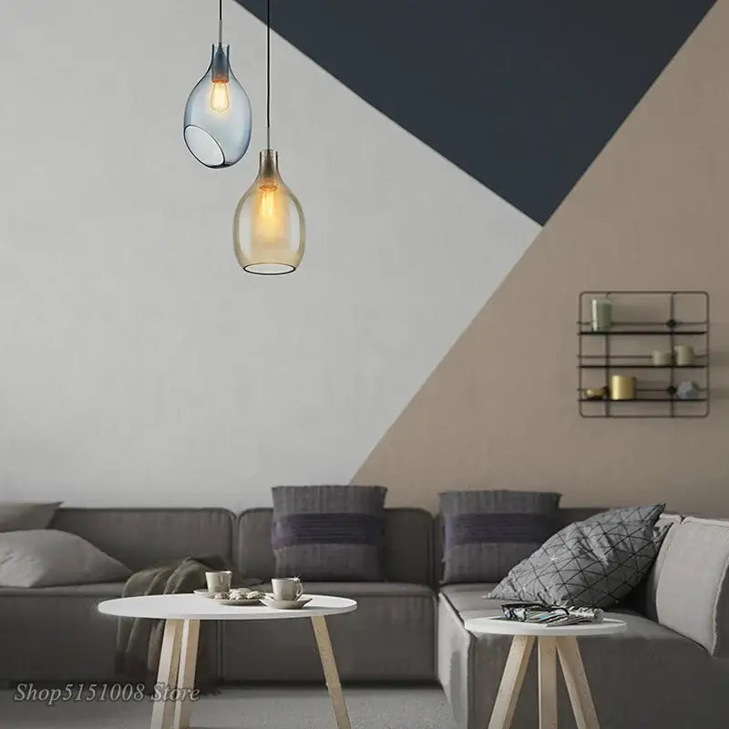 Two hanging glass pendant lights with frosted amber-colored shades for modern kitchen lighting