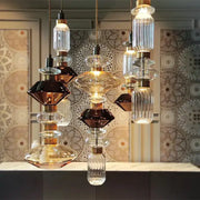 Modern amber and brown glass ballet pendant lamp featuring layered glass and gold metal fittings for dining room