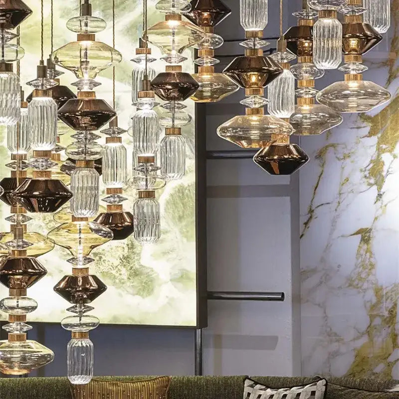 A modern amber and brown glass ballet pendant lamp with cascading glass and brass elements for dining room use