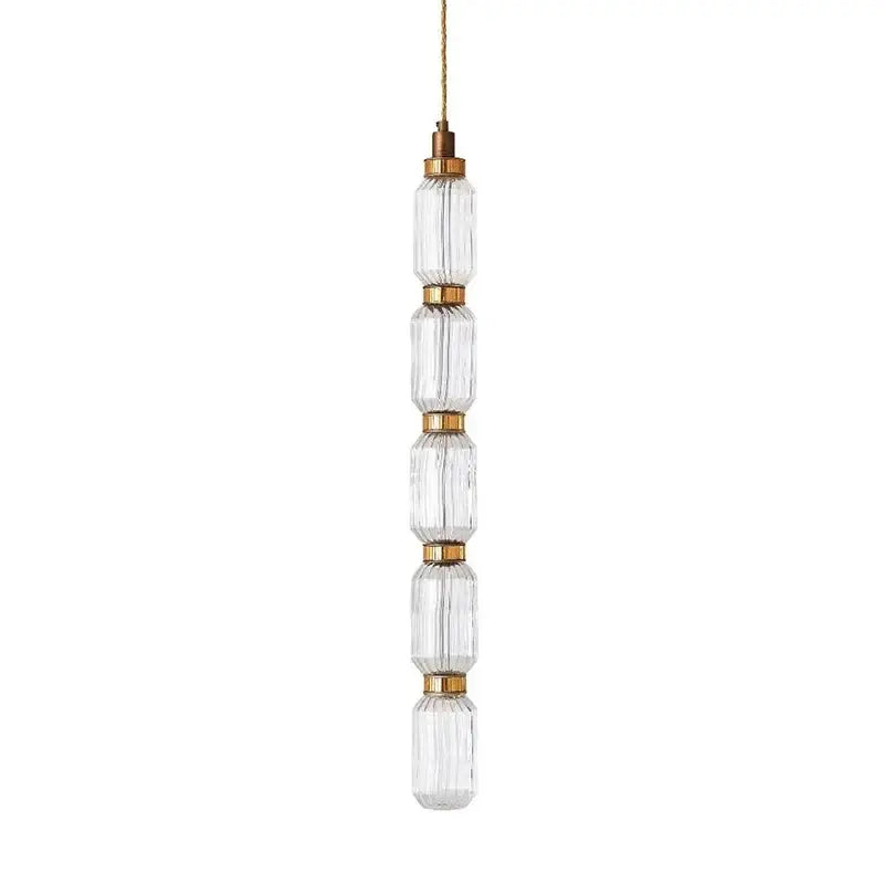 Clear faceted glass ballet pendant lamp with brass accents and gold cord for modern dining room lighting