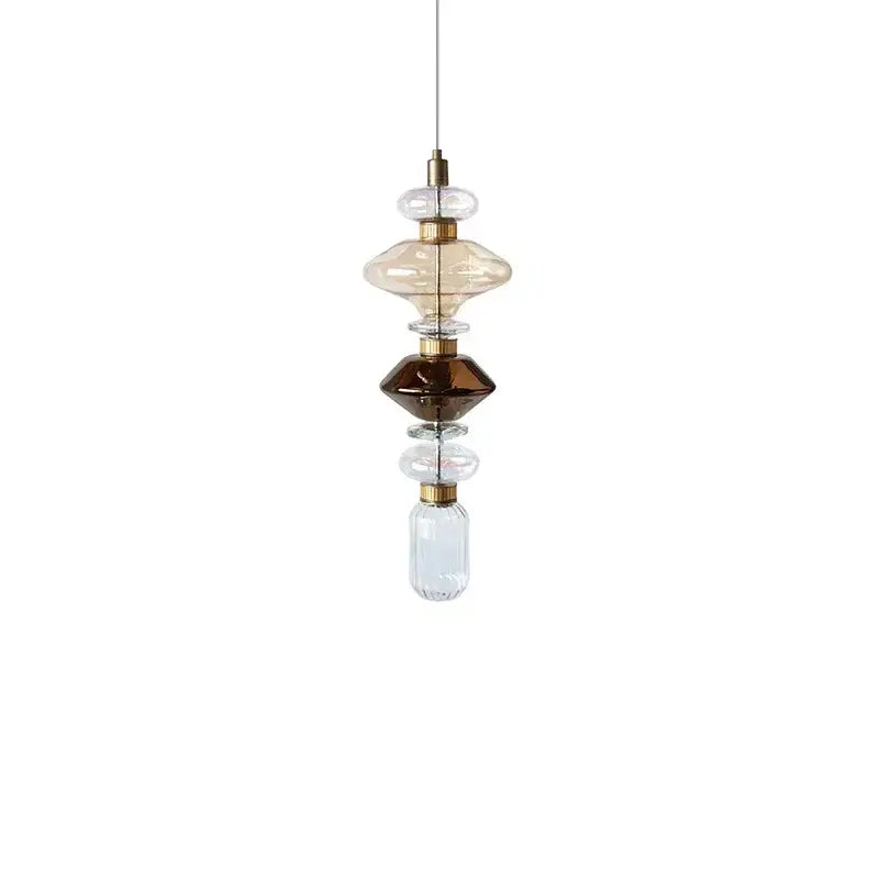 A modern amber and brown glass ballet pendant lamp with stacked orbs and brass accents for dining room use