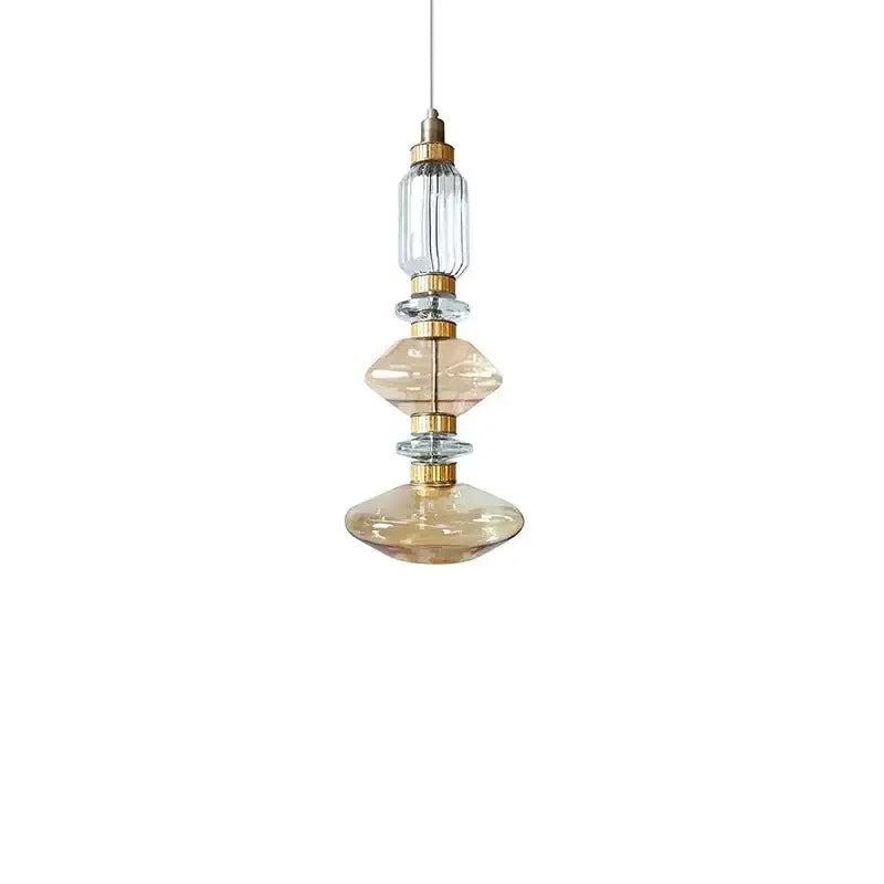 Modern amber and brown glass ballet pendant lamp with stacked clear and amber orbs and polished brass accents for dining room