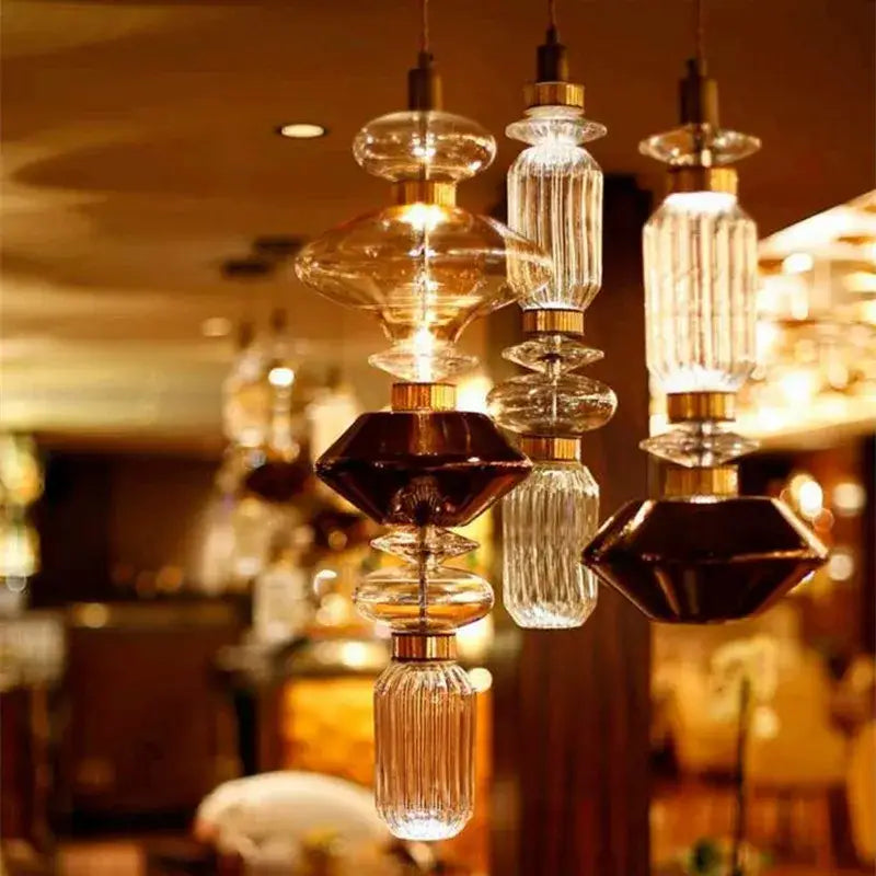 Modern amber and brown glass ballet pendant lamp with faceted glass and gold metal fittings for dining room lighting