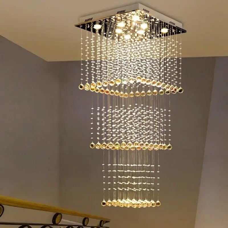 A modern amber and clear decorbites crystal teardrop stairwell chandelier with cascading beads and warm led lights