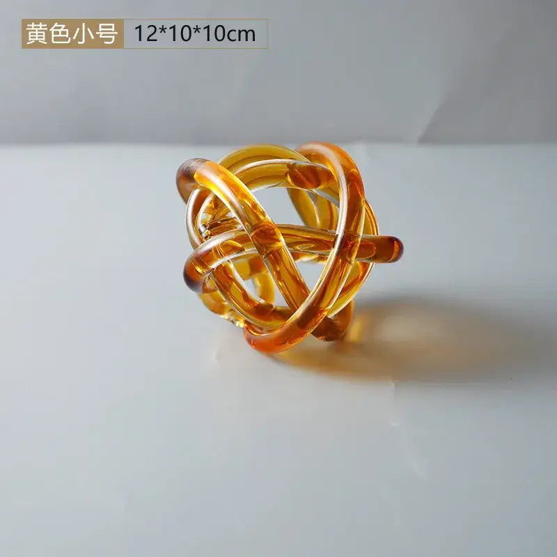 Modern amber and clear glass knot twist sculpture featuring translucent amber tubes for decorbites glass knot decor