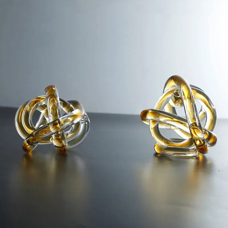 Modern amber and clear glass knot twist sculpture featuring translucent sections for elegant living room decorbites decor