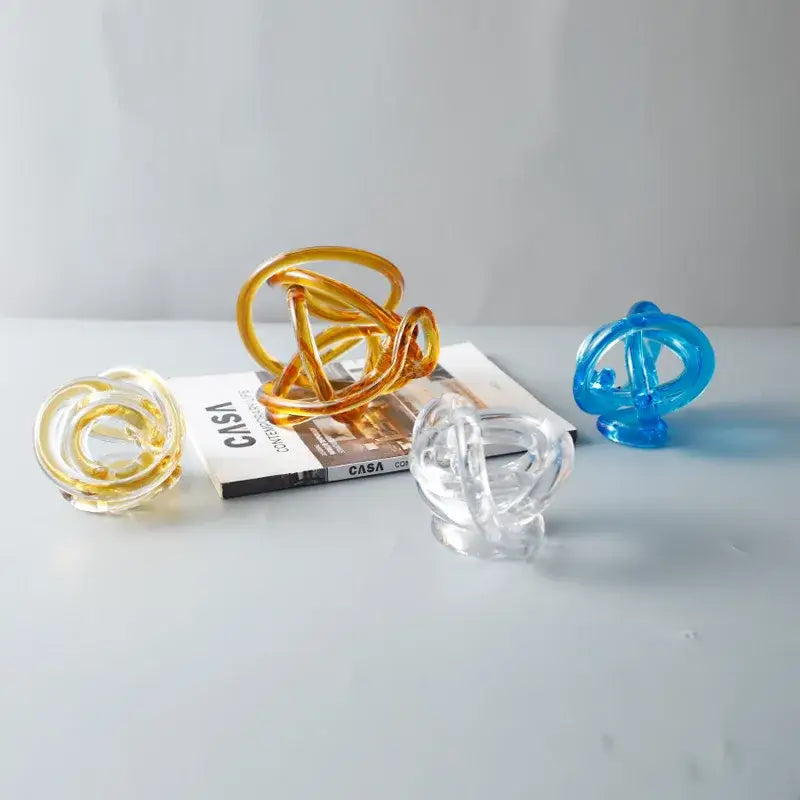 Transparent glass knot twist sculpture with amber clear and blue hues for modern living room decorbites glass knot