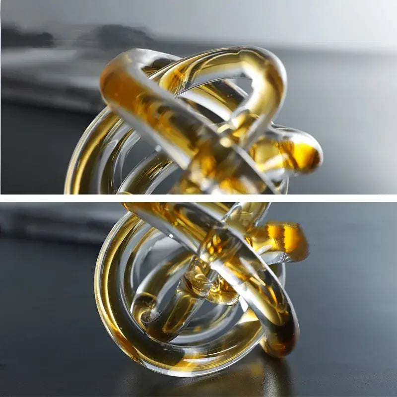 Modern amber and clear glass knot twist sculpture featuring intertwined rings for living room decor by decorbites glass knot