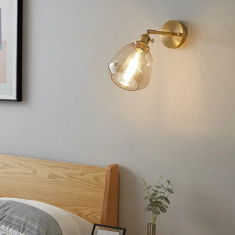 Modern amber clear glass wall sconce with a gold-toned brass base and textured amber clear glass shade decorbites clear glass