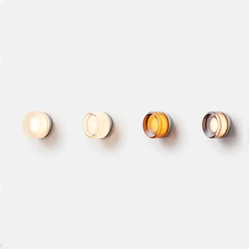 Four modern amber and cream glass sconce led wall lamps with frosted shades emitting warm amber glow for living room