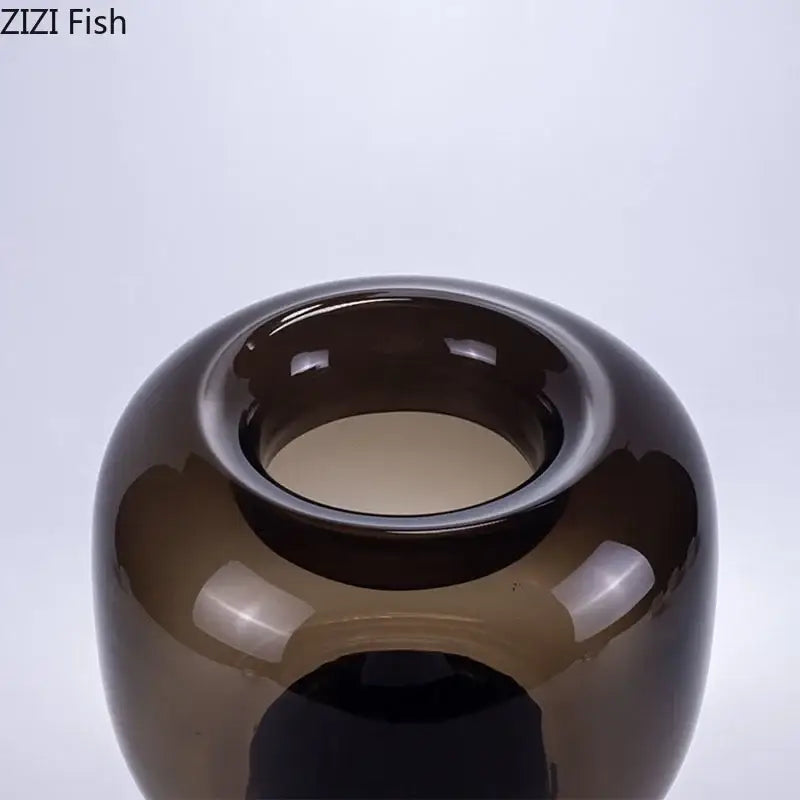 A sleek dark amber glass vase with a smooth rounded body and wide glossy rim for decorbites dark glass office decor