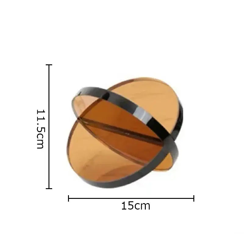 Modern amber geometric cross ornaments feature sleek amber glass orbs with glossy black metallic bands for stylish bookends