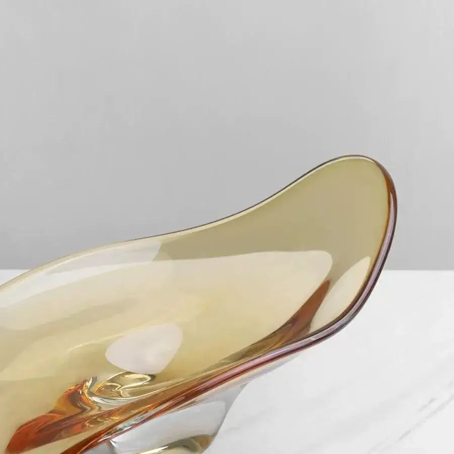 A modern amber geometric glass bowl tray with sleek flowing design and subtle reflective highlights for decorbites decor