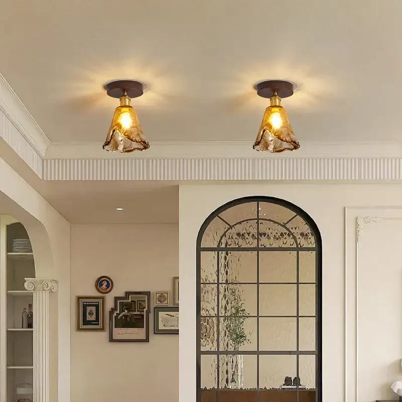 Two amber glass pendant led ceiling lamps with brass fixtures for modern dining room lighting