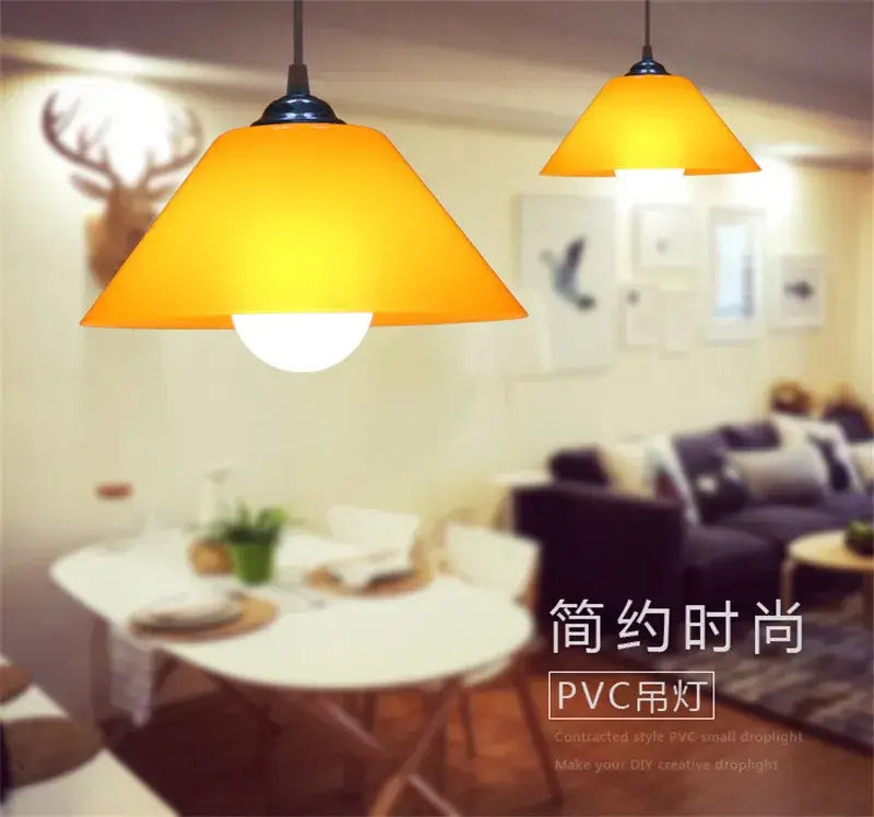 Modern amber glass pendant light with warm yellow-orange conical shade and black iron finish for dining room use