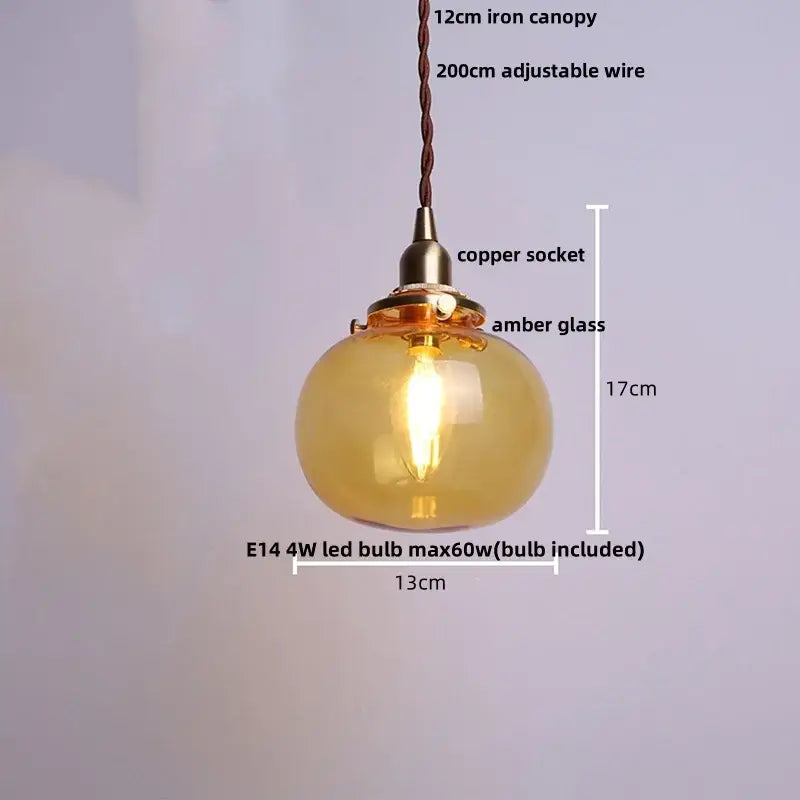 Modern amber glass ball led pendant light with warm amber glass, copper socket, and braided wire suspension for dining room
