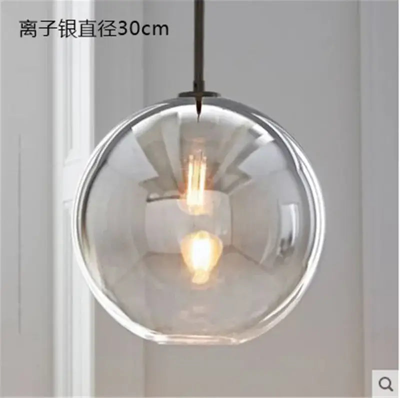 A modern amber glass ball led pendant light with clear globe and exposed filament bulb for kitchen decorbites decor