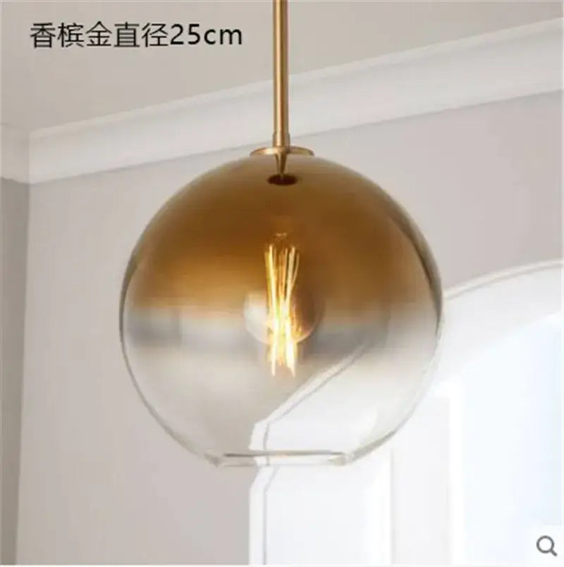 Modern amber glass ball led pendant light with gradient gold finish and brass rod featuring exposed filament bulb decorbites glass ball