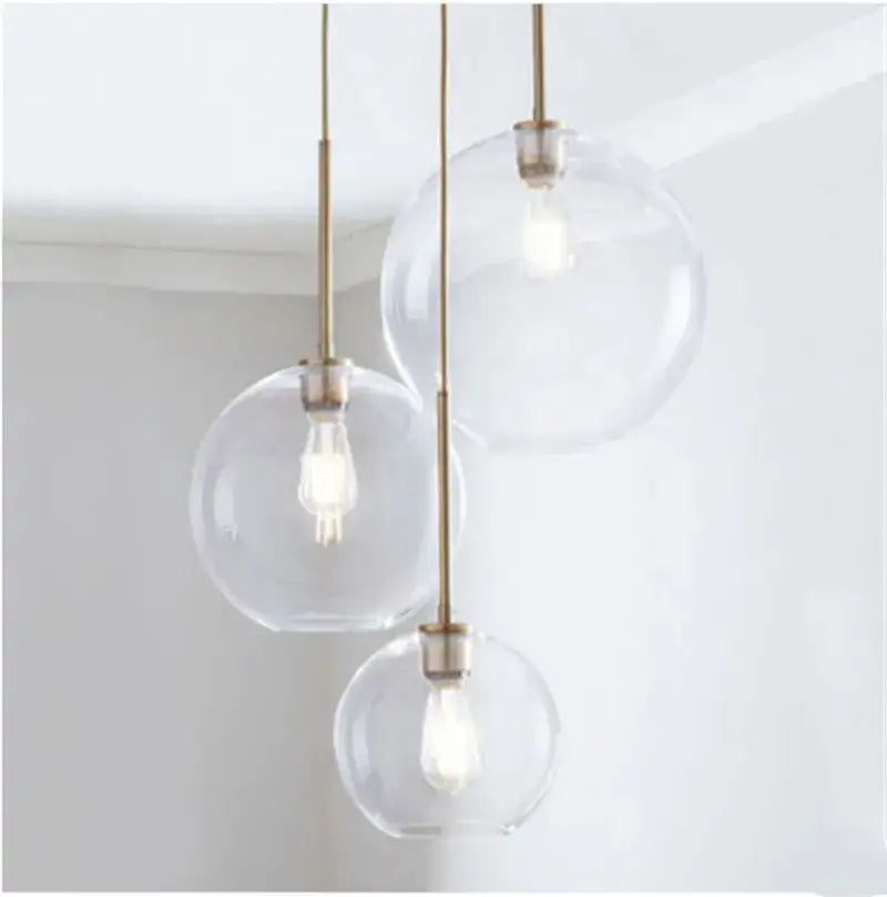Three clear pendant light glass ball led globes with brass-finished rods for modern kitchen decorbites decor