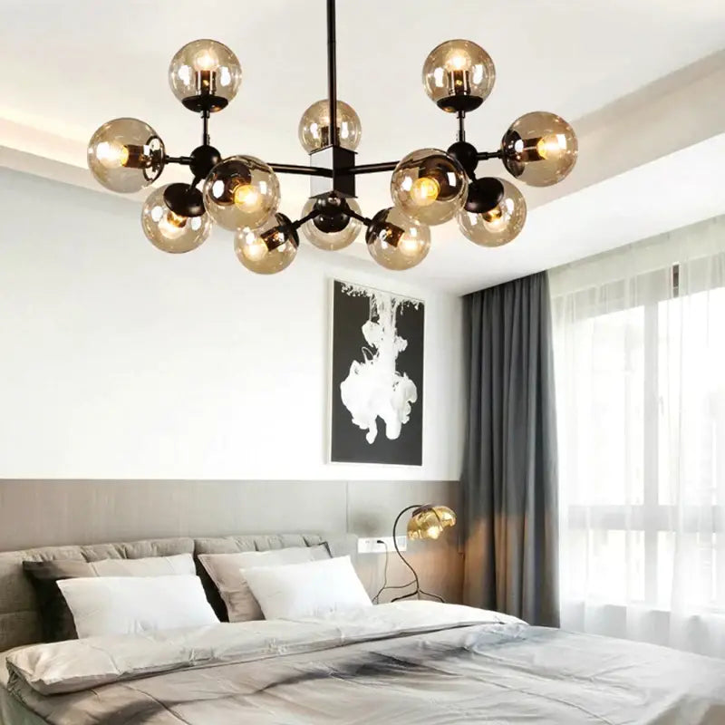 Modern amber glass ball pendant light chandelier with multiple amber-tinted glass globes on black metal frame