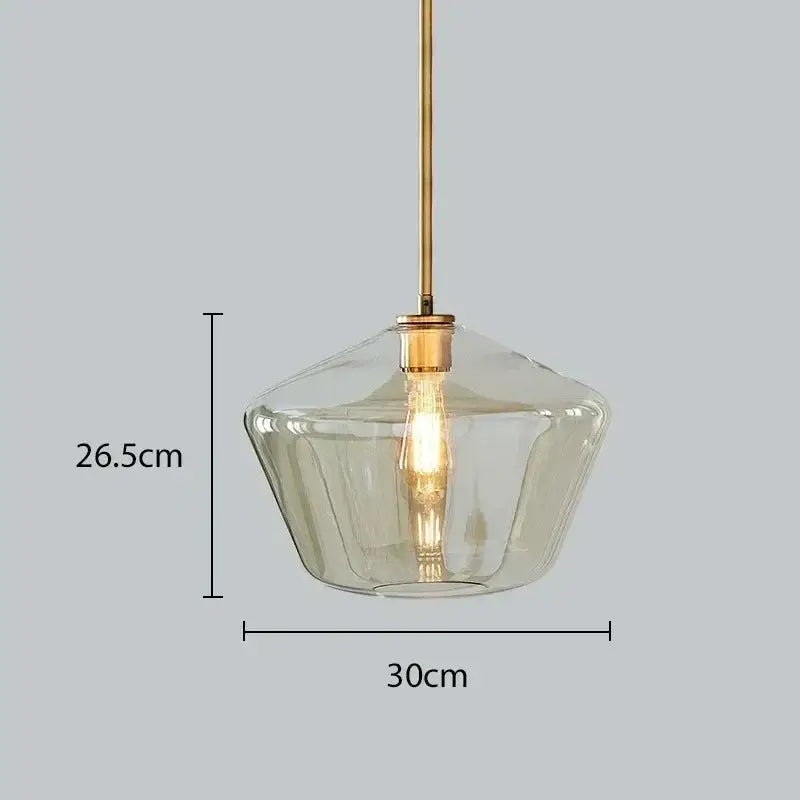 A modern amber glass chandelier pendant light with a clear faceted shade and brass rod for dining room or living room