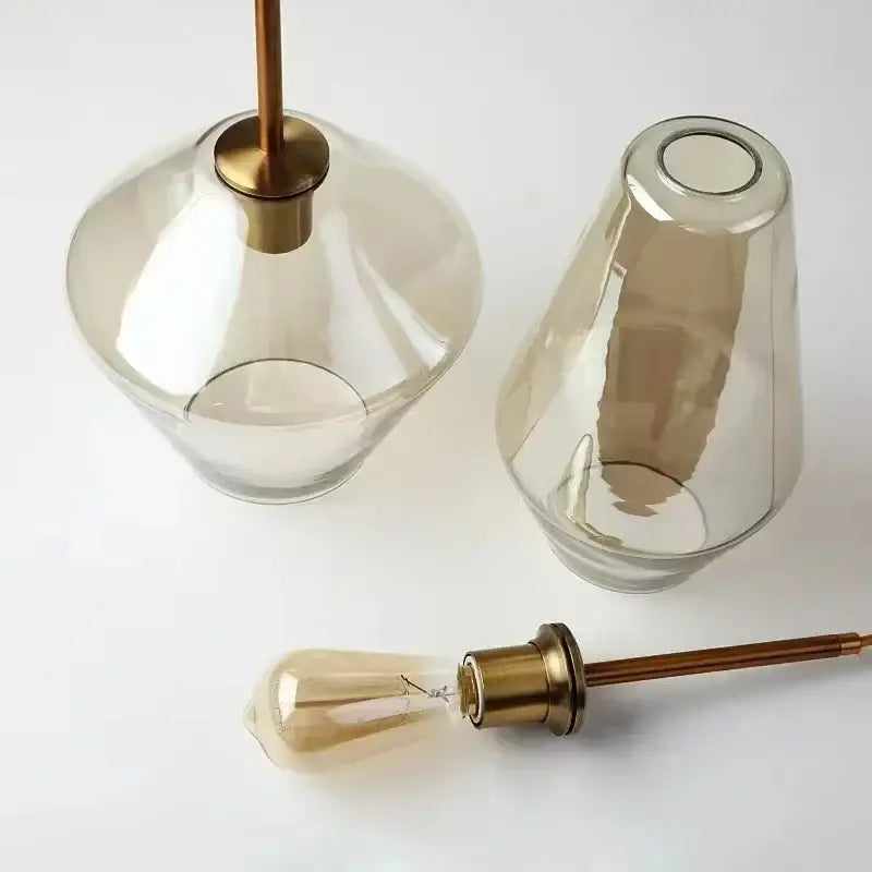 Two smoked glass pendant light shades with brass hardware and vintage filament bulbs for modern living room chandelier
