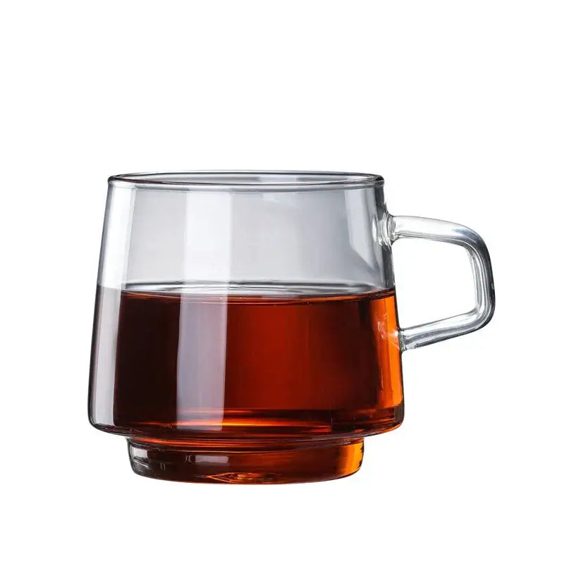 Modern amber glass coffee mug with black rim and sturdy handle filled with amber liquid by decorbites glass coffee