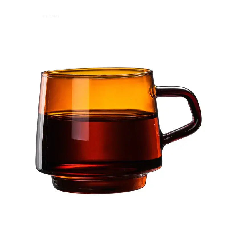 Modern amber glass coffee mug with black rim and dark brown handle filled halfway with coffee for decorbites glass coffee